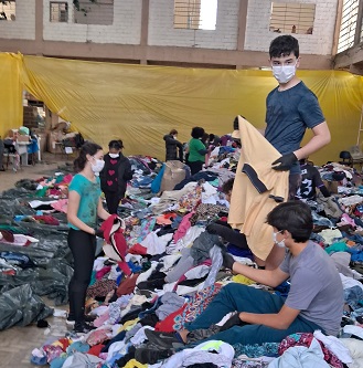 Jovens ajudam a separar as doações de roupas.